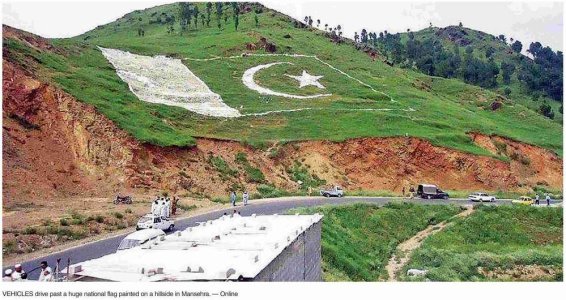Vehicles-drive-past-a-huge-national-flag-painted-on-hillside-mansehra.jpg