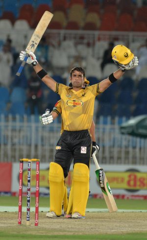 Iftikhar Ahmed raises his bat after completing his hundred.jpg