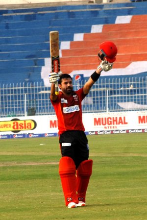 Muhammad Rizwan raises his bat after completing hundred.jpg