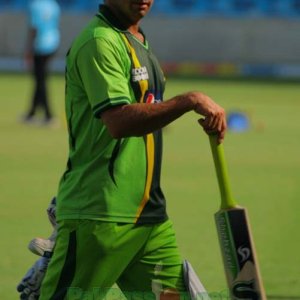 Saeed Ajmal dangles the bat as he walks along