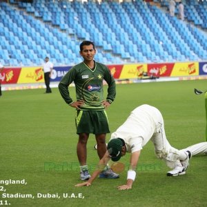 Trainer Saboor Ahmed looks into the camera while Umar Gul does some stretch