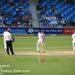 Monty Panesar walks back to his bowling mark as Simon Taufel watches