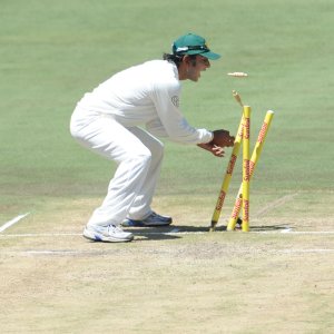 Faisal Iqbal dismantles the stumps for a run out