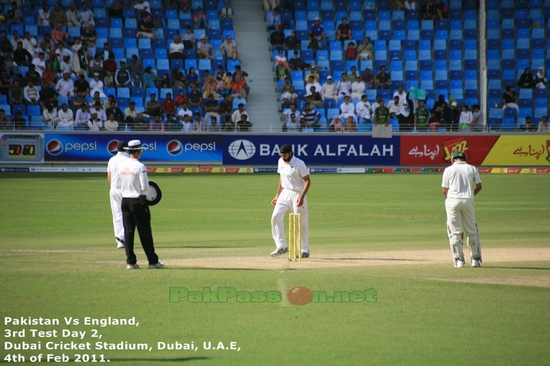 Monty Panesar walks back to his bowling mark as Simon Taufel watches