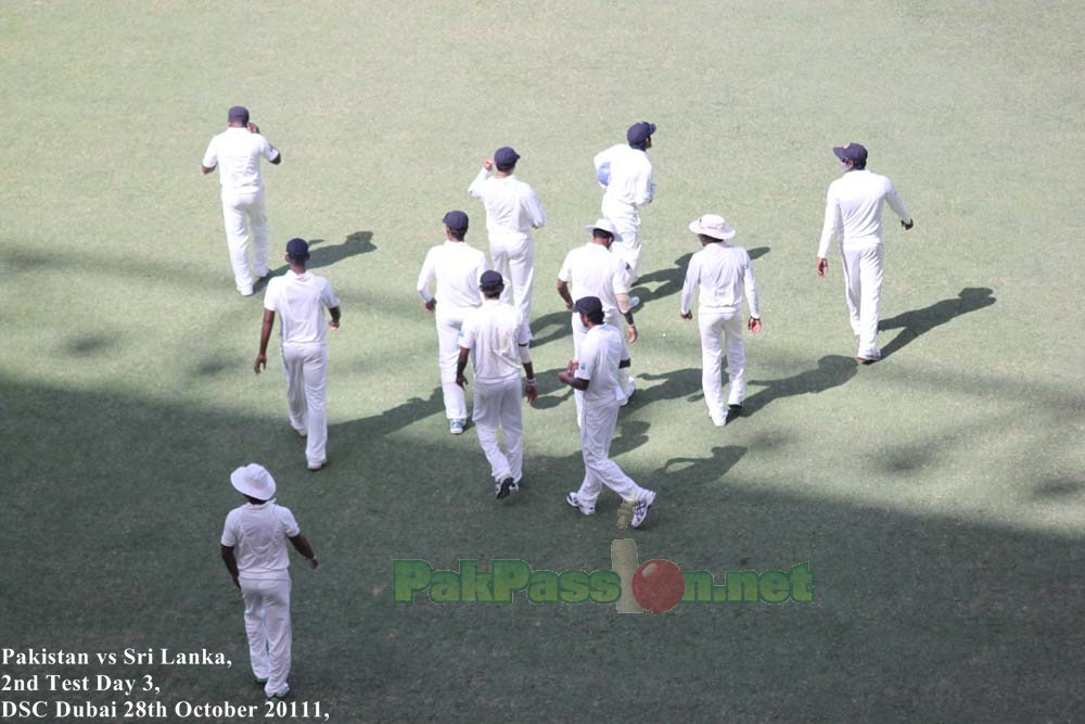 The Sri Lankan team players march towards their fielding positions