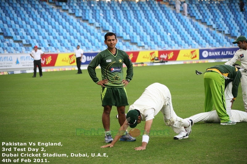 Trainer Saboor Ahmed looks into the camera while Umar Gul does some stretch